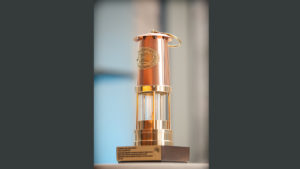 The Miner's Lamp Award trophy. It is a gold trophy shaped like the cylindrical lamp traditionally used by miners