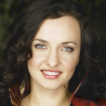 a close-up photo of a woman with dark brown curly hair